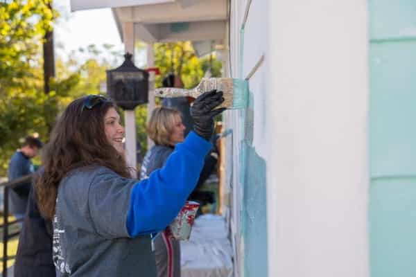 volunteer painting a house